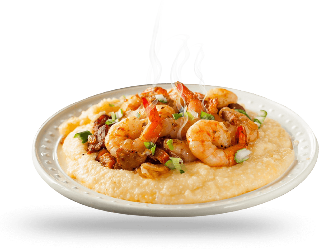 A plate of shrimp and grits on top of a table.